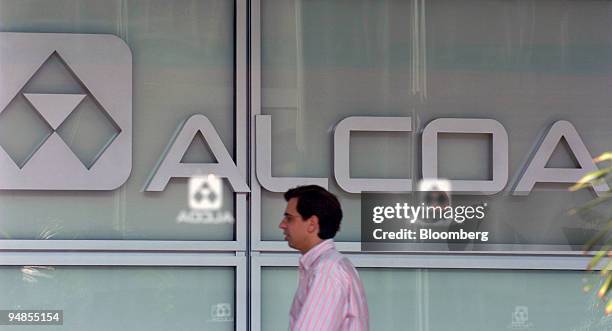 An Alcoa employee walks past the company's sign at the headquarters of Alcoa Inc., on the Allegheny River in Pittsburgh, Pennsylvania, July 6, 2005.