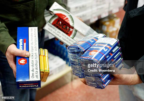 Customers hold products that are for sale at the Toeckfors Shopping Mall on Saturday, February 11, 2006 in Toeckfors, Sweden. Olav Thon has become a...