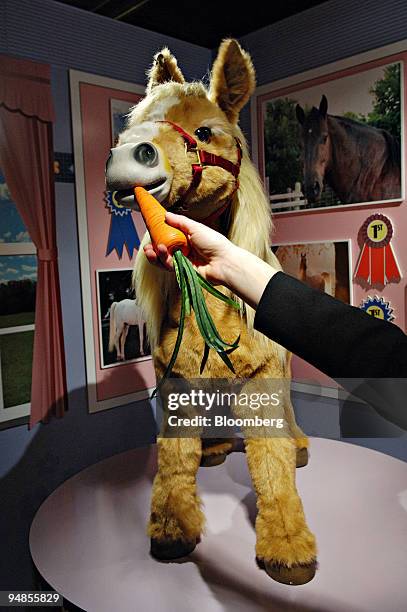 Mechanical pony named 'Butterscotch' nibbles a carrot held by a product demonstrator in the Hasbro showroom in New York during the International Toy...