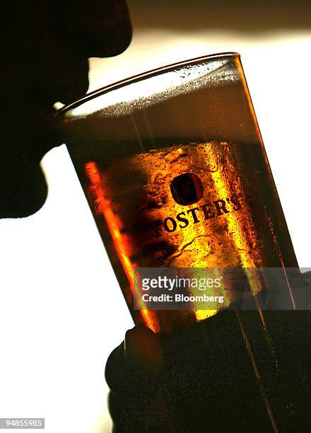 Customer drinks a pint of Fosters lager at a public house in Hornchurch, Essex, U.K., on Tuesday, Aug 26, 2008. Heineken NV, the biggest Dutch...