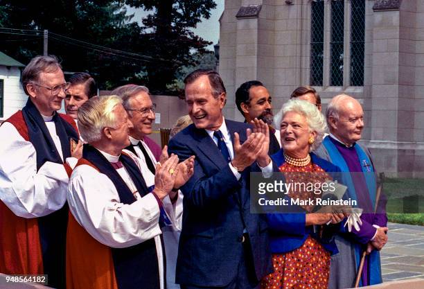 President George HW Bush and First Lady Barbara Bush , along with various unidentified religious leaders, applaud during the dedication ceremony of...