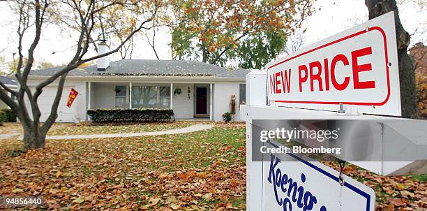 New price sign stands atop a sign outside a home in Park Ridge, Illinois, U.S., on Thursday, Nov. 6, 2008.