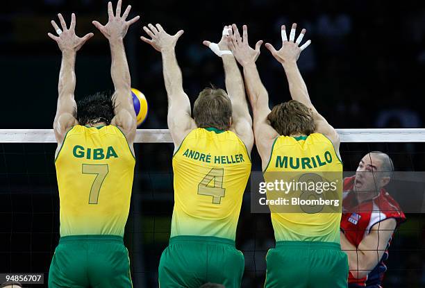 Gilberto Godoy Filho, left, Andre Heller, center, and Murilo Endres of Brazil try to block a ball in the men's volleyball gold medal match against...