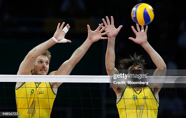 Gilberto Godoy Filho, right, and Andre Heller of Brazil, try to block a ball in the men's volleyball gold medal match against the U.S. On the final...