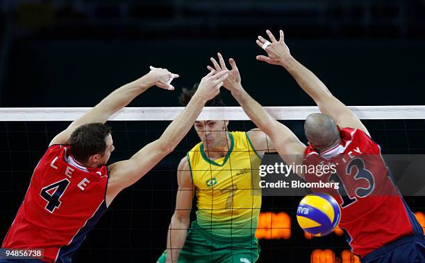 David Lee, left, and Clayton Stanley, right, of the U.S., try to block a ball hit by Gilberto Godoy Filho of Brazil, in the men's volleyball gold...