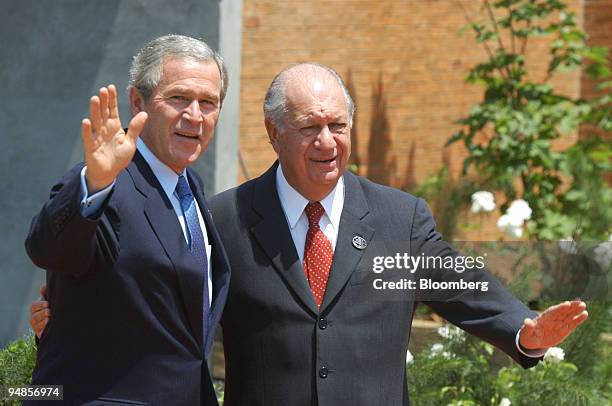 Chilean President Ricardo Lagos, right, and US President George W. Bush wave to photographers as Lagos welcomes Bush to the Riesco Showcenter for the...