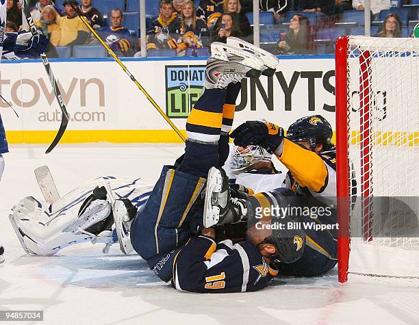 Tim Connolly of the Buffalo Sabres is upended in the goal crease getting tangled wtih teammate Clarke MacArthur and goaltender Jonas Gustavsson of...