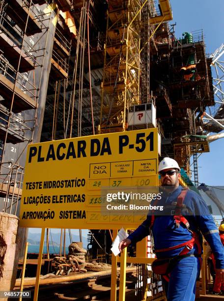 Rig worker walks past the Petroleo Brasileiro SA P-51 oil platform at the Keppel-Fels Shipyard in Angra dos Reis, Rio de Janeiro in Brazil, on...