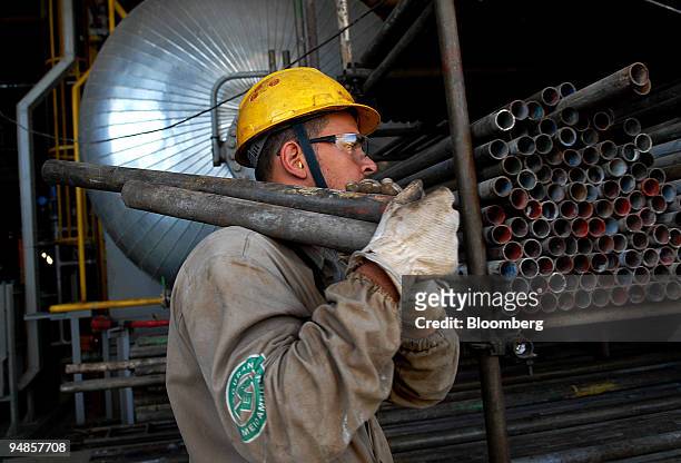 Rig worker carries pipes on the Petroleo Brasileiro SA P-51 oil platform at the Keppel-Fels Shipyard in Angra dos Reis, Rio de Janeiro in Brazil, on...
