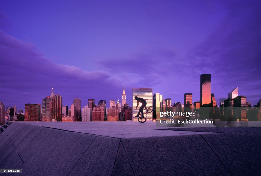 BMX Biker with skyline of New York at sunset