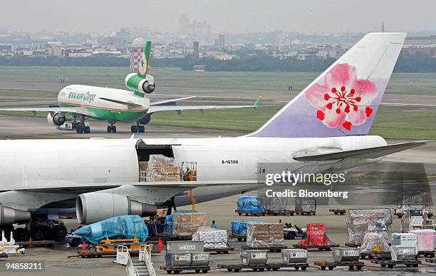 Employees of China Airlines load up a cargo jet at the Taiwan Taoyuan International Airport in Taoyuan, Taiwan, on Tuesday, April 29, 2008. China...