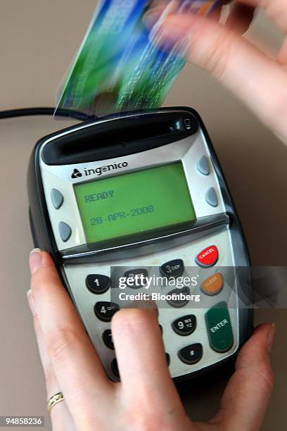 Woman uses a chip and pin machine in London, U.K., on Monday, April 28, 2008. Cards containing an embedded data chip and protected by a PIN number...