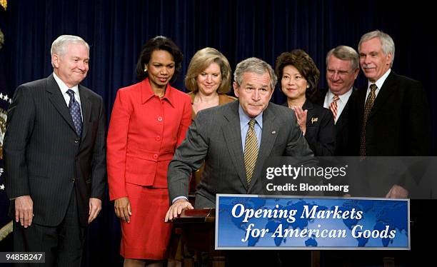 President George W. Bush, foreground, looks up after signing a letter asking Congress to complete the Colombia Free Trade Agreement at the White...