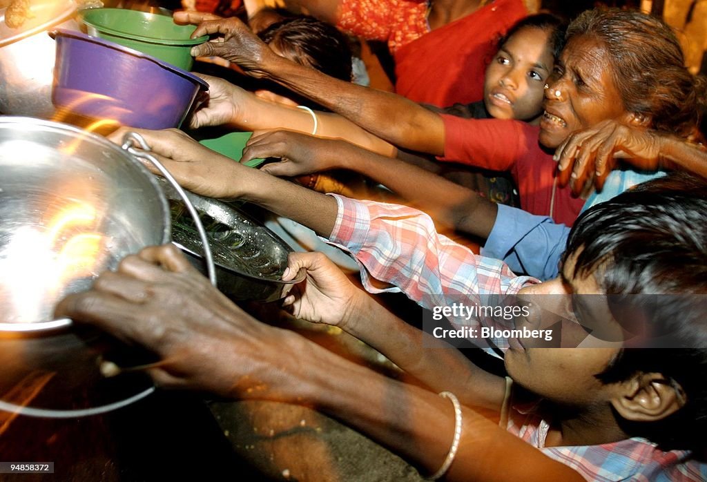 People reach for food outside a temple in Nagapattinam, Indi