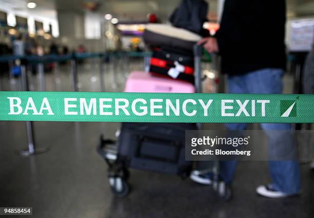 Passenger stands by a BAA emergency exit sign at Gatwick airport in Crawley, Sussex, U.K.,on Wednesday, Aug. 20, 2008. Global Infrastructure...