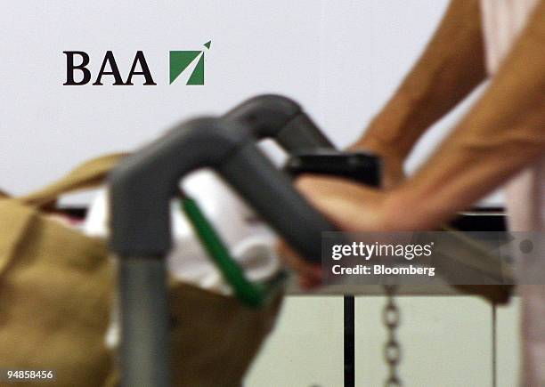 An airline passenger walks past a BAA sign at Gatwick airport in Crawley, Sussex, U.K.,on Wednesday, Aug. 20, 2008. Global Infrastructure Partners,...