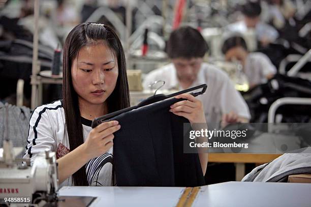 Worker makes a garment for the "Venetia" brand, developed by Jiangsu Sunshine Co. Ltd., at their textile factory at Jiangyin, Jiangsu province,...