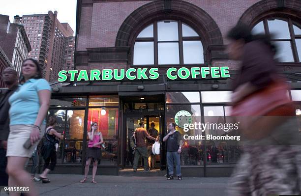 Pedestrians walk past a Starbucks Coffee store on Astor Place in New York City July 2, 2005.