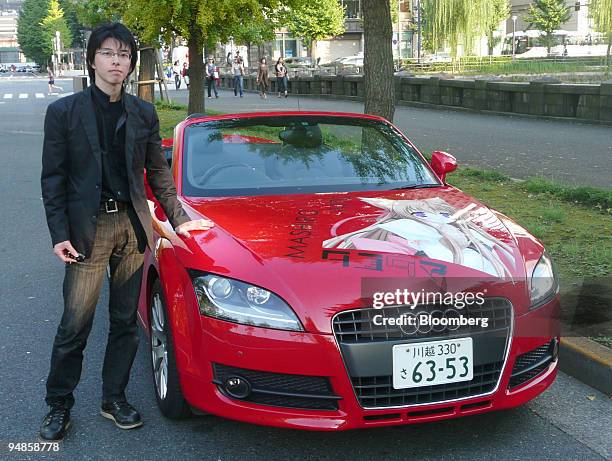 Masaya Taniguchi poses next to an Audi TT Roadster decorated with an illustration of Mito Mashiro, a character from the Tayutama video game, in...