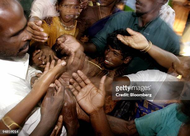 Man passes out food vouchers to people in Nagapattinam, India on December 31, 2004. As the death toll from the December 26 earthquake-triggered...