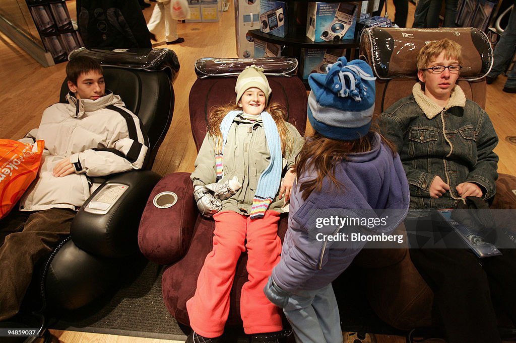 Young people try out the massage chairs at a Sharper Image s