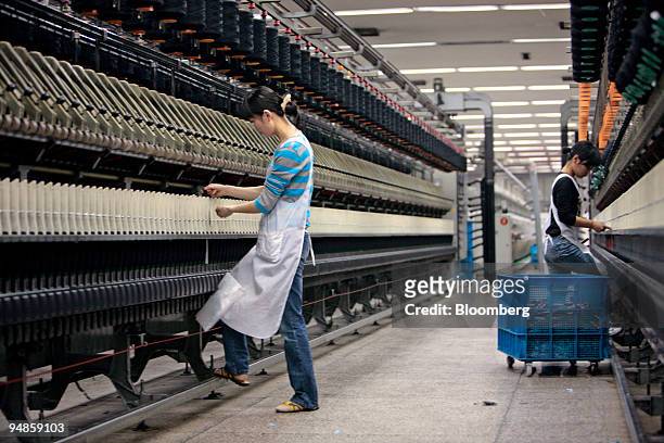 Workers handle yarn at a weaving machine at the Jiangsu Sunshine Co. Ltd. Textile factory at Jiangyin, Jiangsu province, China, on Thursday, April...