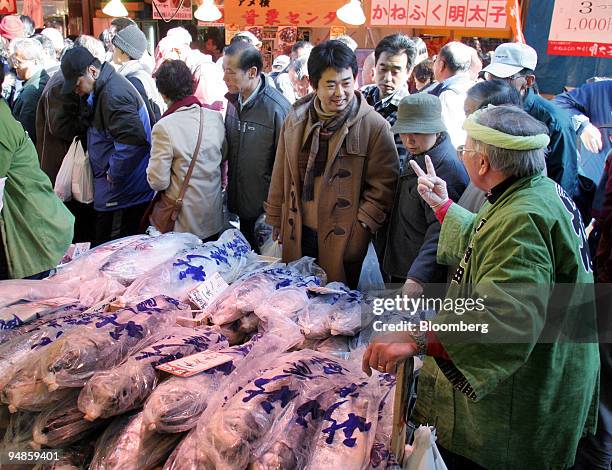 Fishmonger offers salmon to year-end shoppers at the Ameyoko market in Tokyo, Japan on Thursday, December 30, 2004.