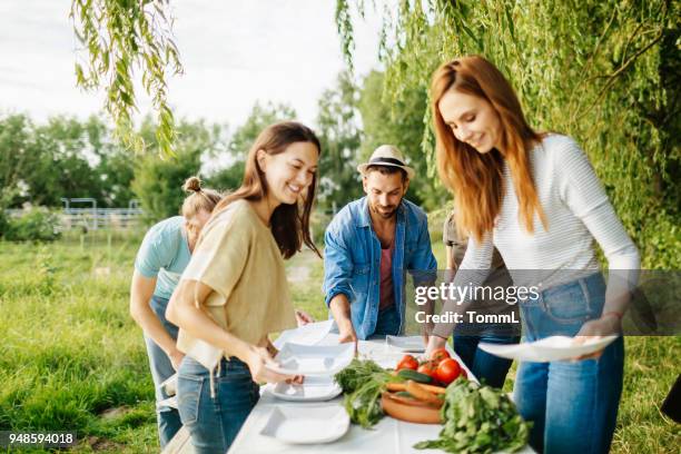 vänner förbereda utomhus lunch på lokal gård - table garden bildbanksfoton och bilder