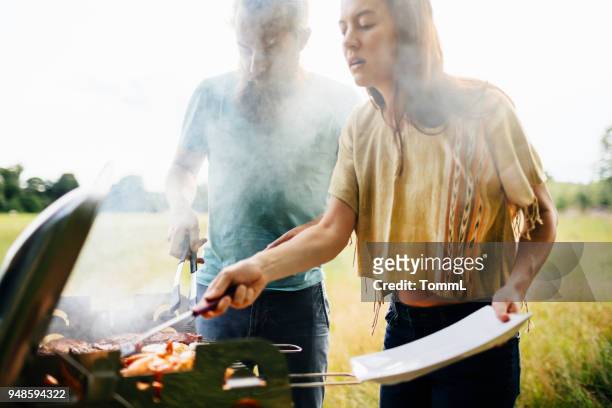couple cooking food on bbq for friends - couple grilling stock pictures, royalty-free photos & images