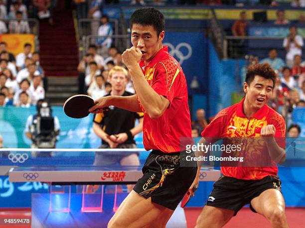Wang Liqin, center, and Wang Hao, right, both of China, celebrate a winning point against Timo Boll and Christian Suss, of Germany, during the gold...