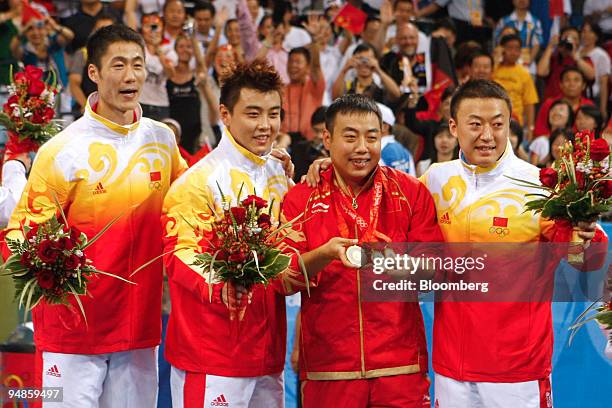 Wang Liqin, left, Wang Hao, second from left, and Ma Lin of China, celebrate with Liu Guoliang, China's national table tennis coach, after winning...