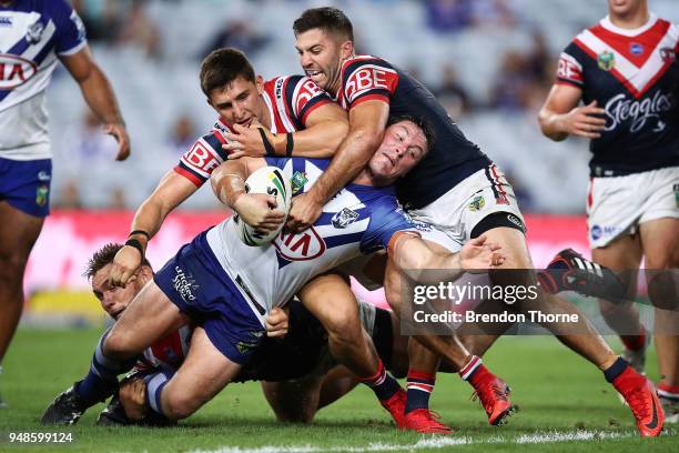 Joshua Jackson of the Bulldogs is tackled by Roosters defence during the round seven NRL match between the Canterbury Bulldogs and the Sydney...