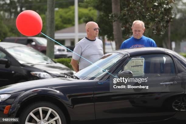 Dave Hedges left, of Hornell, New York, and his son Scott Hedges of Tarpon Springs, Florida, look at a MX-5 Miata at the Ed Morse Mazda dealership in...