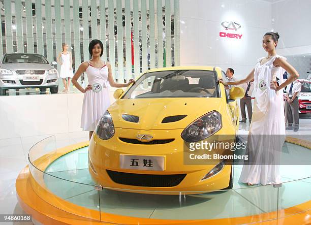 Models pose next to the newly released Chery Faira car during a media preview at the Beijing International Automotive Exhibition in Beijing, China,...