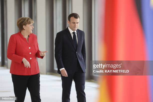 German Chancellor Angela Merkel and French President Emmanuel Macron arrive for a joint press conference at the Humboldt Forum in the still under...