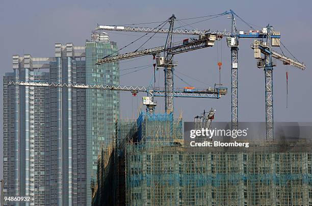 Cranes rise above apartment blocks under construction Wednesday, December 22, 2004 in Hong Kong, China. Hong Kong's stocks may be headed for their...