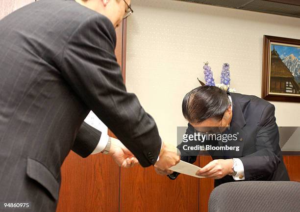 Kansai Electric Power Co. President Yosaku Fuji, right, bows in apology as he receives a letter on the results of inspections at Kansai Electric's...
