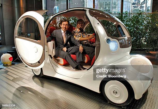 Nissan Motor Co. Chief designer Shiro Nakamura, left, and Artist Takashi Murakami, right, pose inside the "Pivo" concept car at a press briefing in...