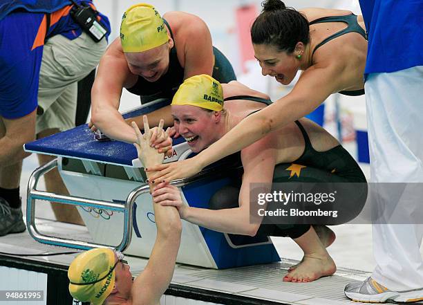 Linda Mackenzie, bottom, Kylie Palmer, top left, Bronte Barratt, center, and Stephanie Rice, all of Australia, celebrate a gold medal win in the...
