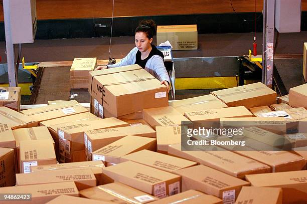 Workers scan and weigh packages at a FedEx Ground facility in Woodbridge, New Jersey on December 16, 2004. FedEx Corp., the No. 2 U.S....