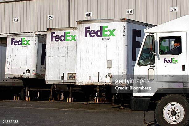 FedEx Ground truck driver drives past trailers being unloaded from within at a FedEx Ground facility in Woodbridge, New Jersey on December 16, 2004....