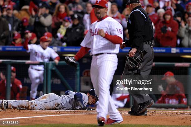 Jason Bartlett of the Tampa Bay Rays, left, lies near home plate after being thrown out as J.C. Romero of the Philadelphia Phillies reacts in the...