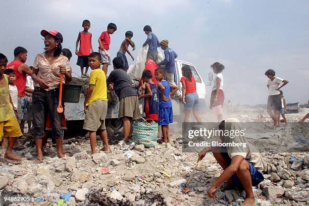 Residents rush to pick through new scraps from a truck dumping refuse in the urban poor community of San Roque in Quezon City, the Philippines, on...