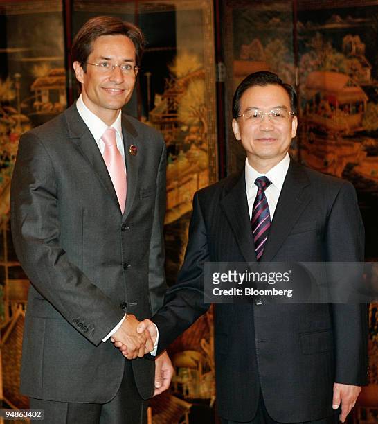 Chinese Premier Wen Jiabao, right, shakes hands with Austrian Finance Minister Karl-Heinz Grasser at a meeting of European and Asian finance...