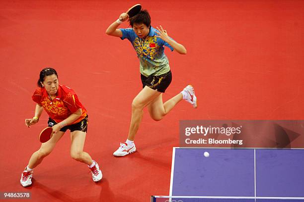 Wang Nan, left, and Li Xiaoxia, both of the Chinese Olympic women's table tennis team, practice during a training session on day four of the 2008...