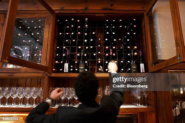 Worker arranges a wine cabinet at Ago, a restaurant located at 377 Greenwich Street in New York, U.S., on Monday, April 7, 2008. Actor Robert DeNiro,...