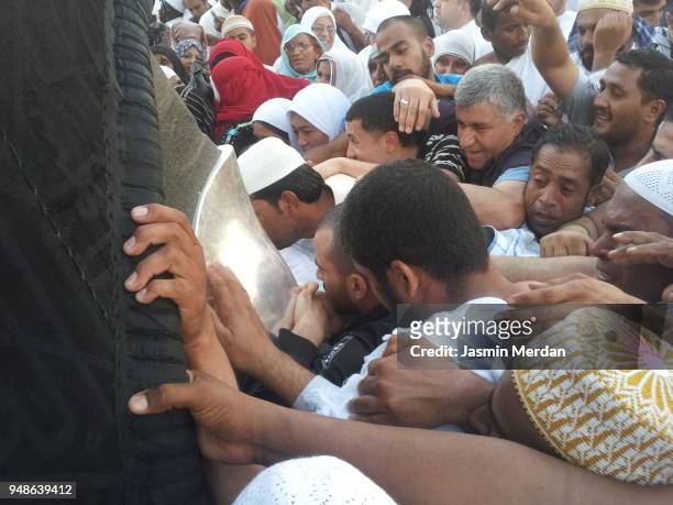 muslim people trying to reach the black stone on kaaba in mecca - kaaba 個照片及圖片檔