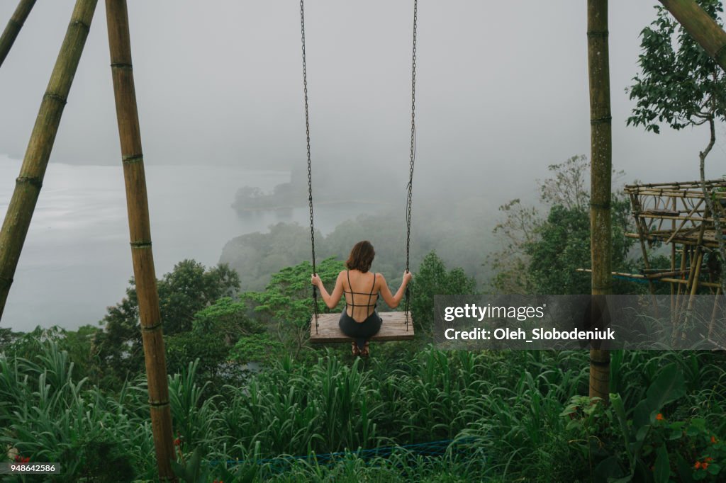 Frau auf der Schaukel über den Dschungel und den See in Bali