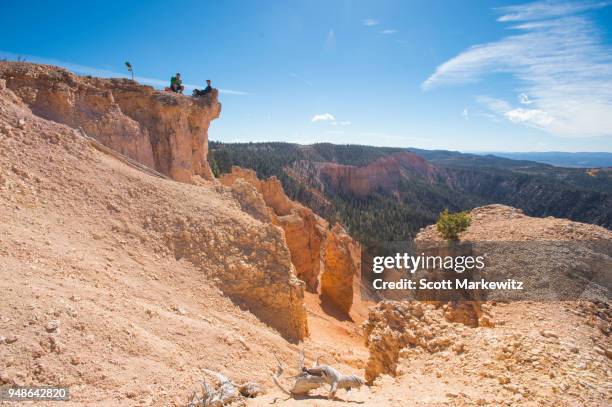 two men sitting on a sandstone ridge line while taking a break from mountain biking - contea di iron foto e immagini stock