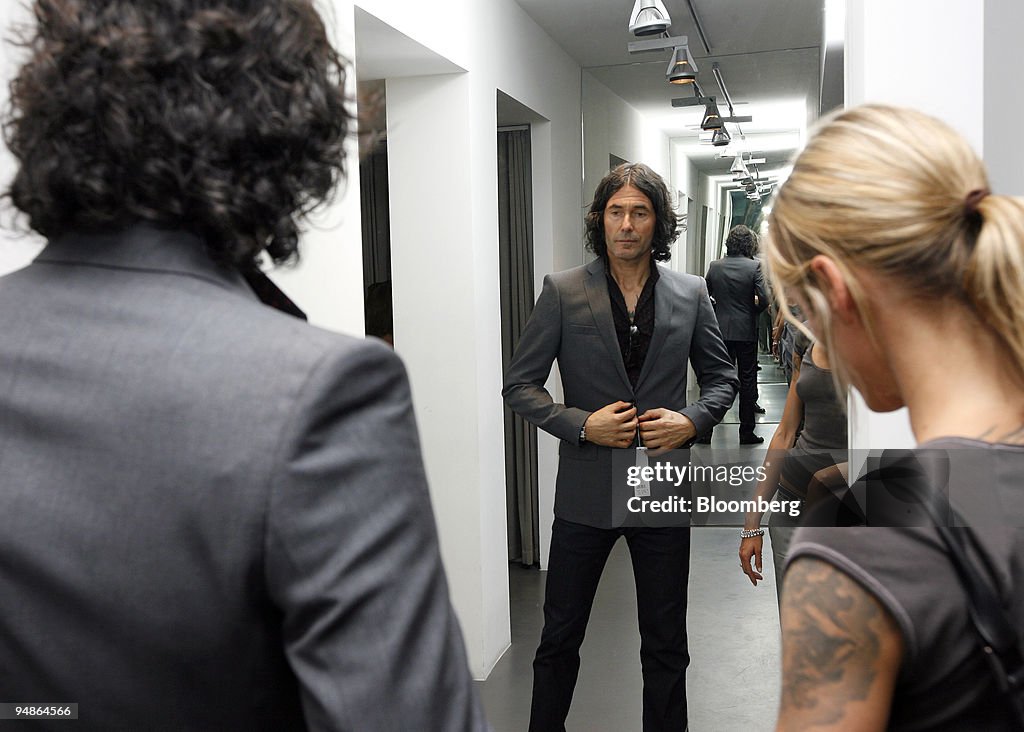 Urs Ehm tries on a jacket in a mirror as Astrid Ermisch look